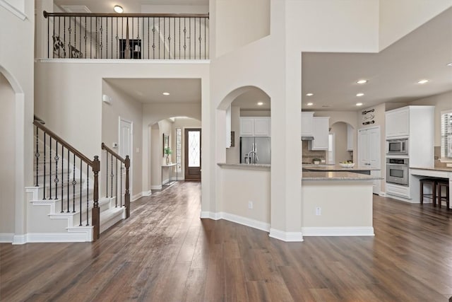 foyer entrance with dark wood-type flooring and a high ceiling