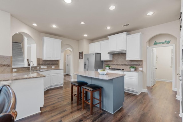 kitchen with a kitchen island, dark hardwood / wood-style floors, white cabinetry, sink, and stainless steel appliances