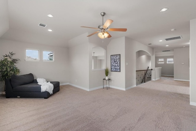 sitting room with ceiling fan, light colored carpet, and a healthy amount of sunlight