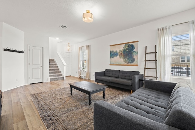 living room featuring a textured ceiling and light wood-type flooring