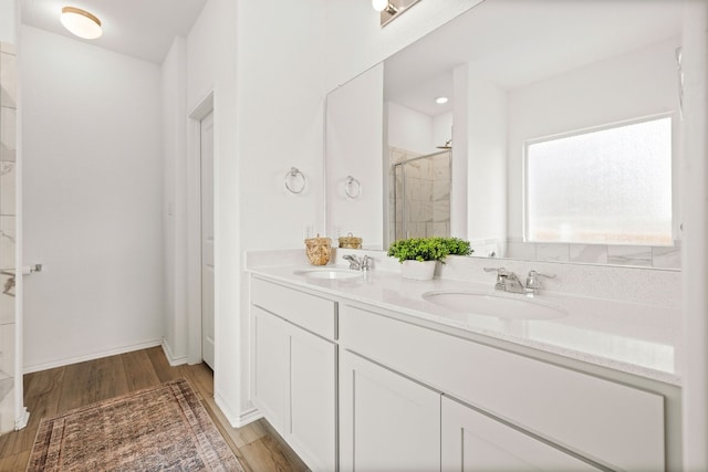 bathroom featuring vanity, wood-type flooring, and tiled shower