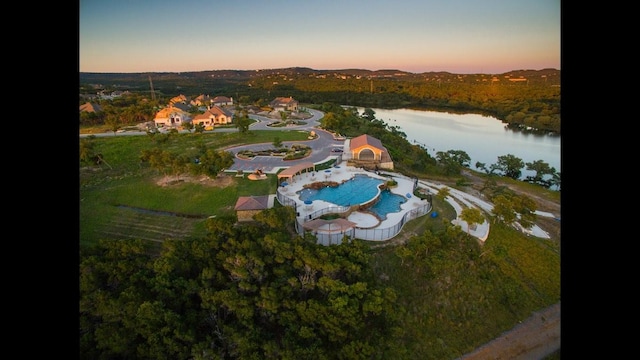 aerial view at dusk featuring a water view