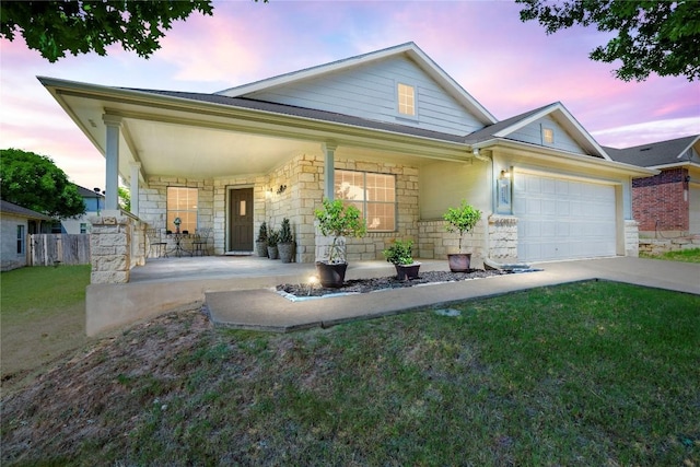 view of front of property with a garage, a porch, and a yard