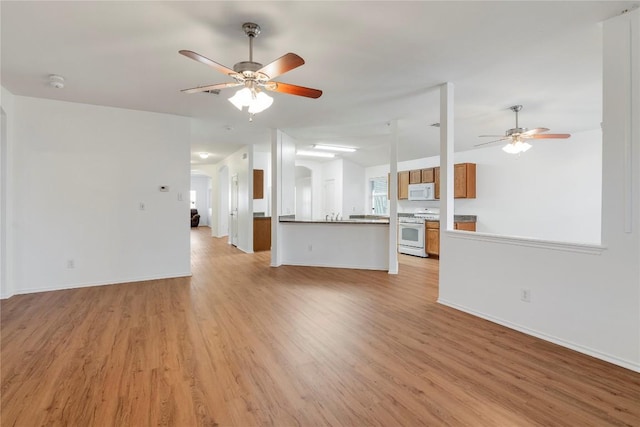 unfurnished living room featuring ceiling fan and light hardwood / wood-style floors