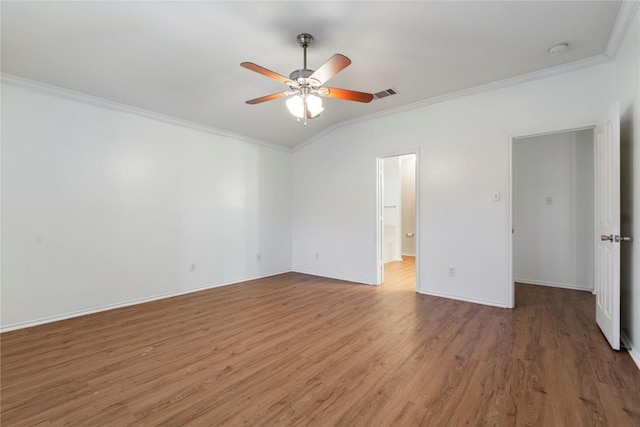 empty room featuring crown molding, ceiling fan, wood-type flooring, and lofted ceiling