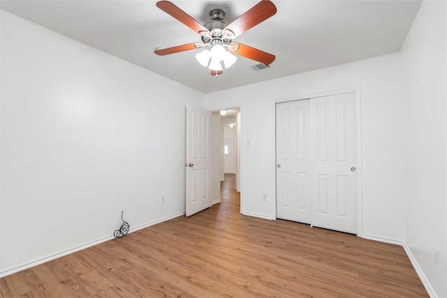 unfurnished bedroom with ceiling fan, a closet, and light hardwood / wood-style flooring