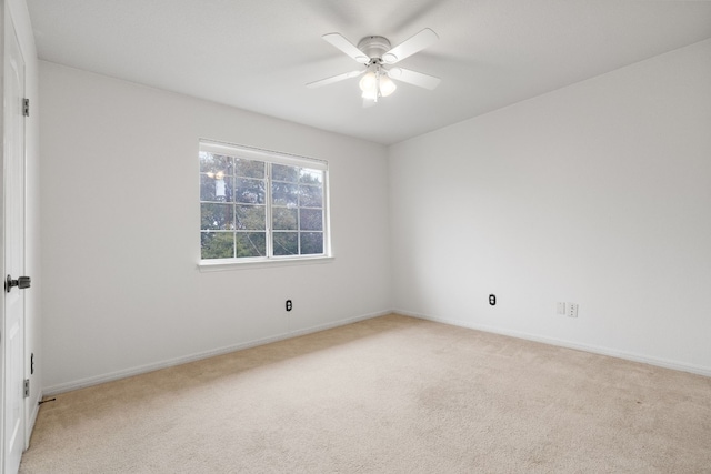 carpeted spare room with ceiling fan