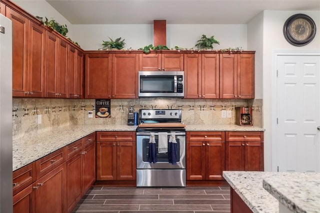 254 Cardinal Loop, Paige, TX 78659 - kitchen with stainless steel appliances, wood finish floors, decorative backsplash, and light stone counters