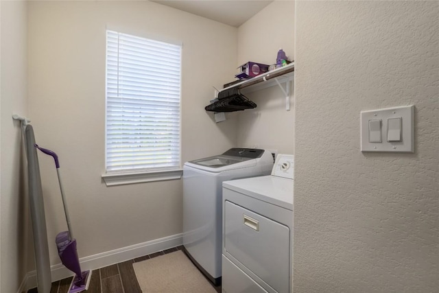 clothes washing area featuring wood tiled floor, laundry area, independent washer and dryer, and baseboards