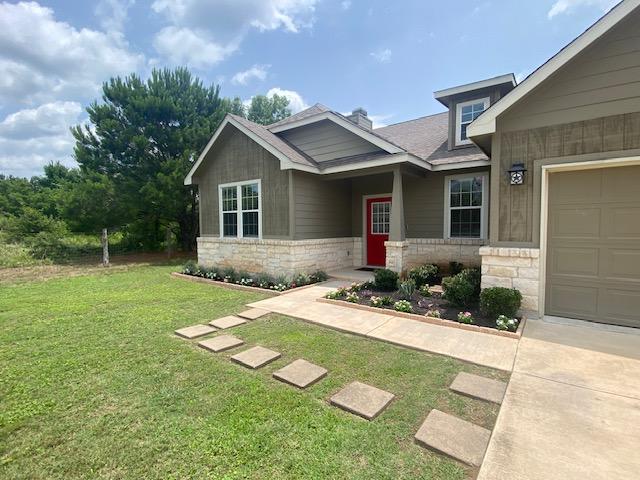 254 Cardinal Loop, Paige, TX 78659 - craftsman house featuring stone siding and a front lawn