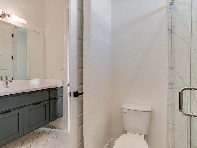 bathroom featuring vanity, a shower with shower door, and toilet