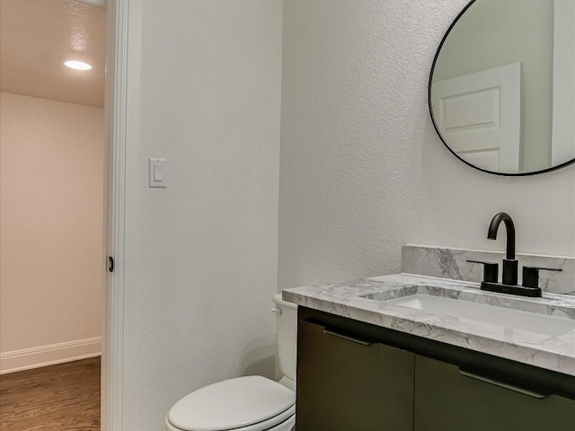 bathroom with hardwood / wood-style flooring, vanity, and toilet