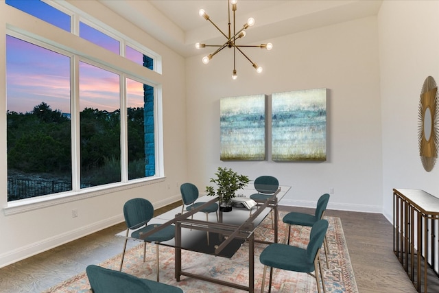 dining space with wood-type flooring, plenty of natural light, and a notable chandelier