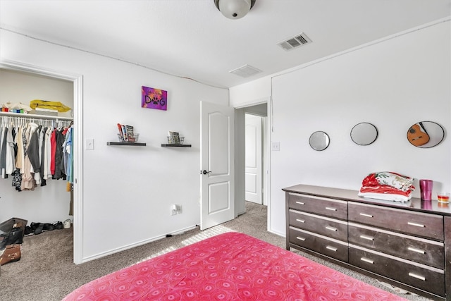 carpeted bedroom featuring a spacious closet and a closet