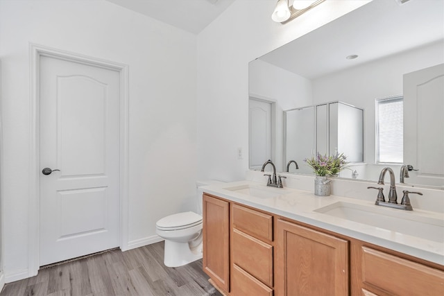 bathroom featuring vanity, an enclosed shower, wood-type flooring, and toilet