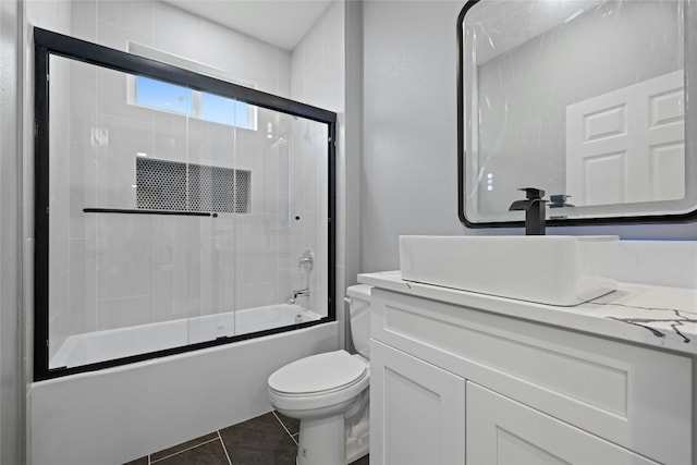 full bathroom with tile patterned floors, vanity, toilet, and combined bath / shower with glass door