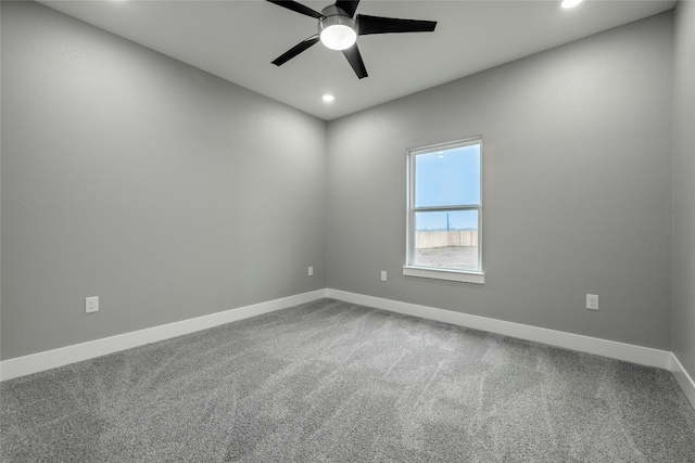 unfurnished room with ceiling fan and carpet