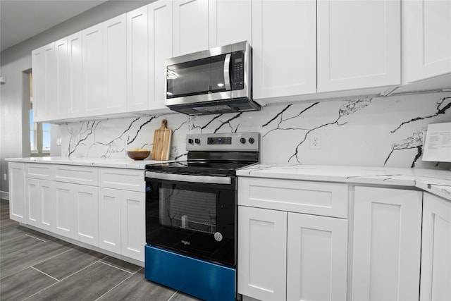 kitchen featuring backsplash, range with electric stovetop, light stone countertops, white cabinets, and dark hardwood / wood-style flooring