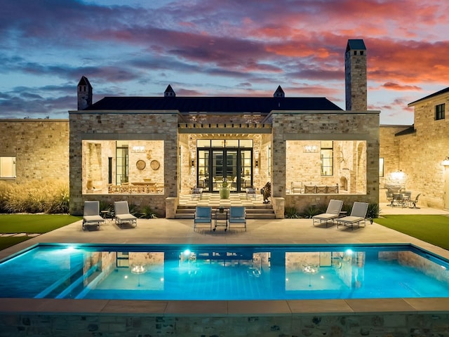 back house at dusk featuring a patio