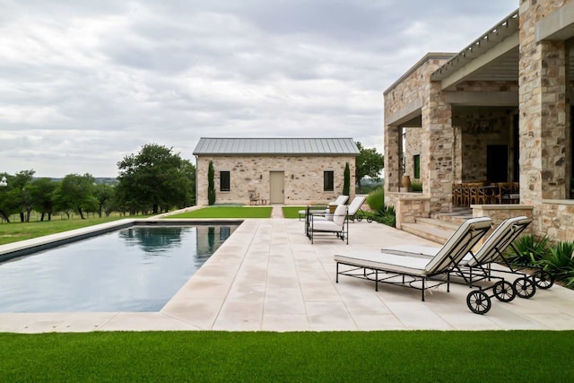 view of pool with an outbuilding, a fireplace, and a patio area