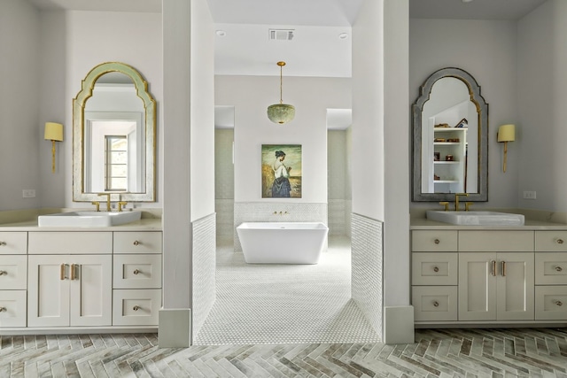 bathroom with a sink, visible vents, and two vanities