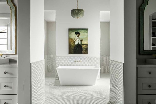 bathroom featuring wainscoting, vanity, and a freestanding tub