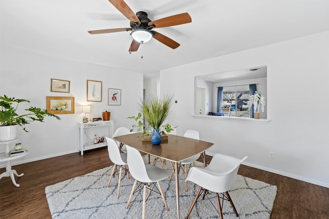 dining room with ceiling fan and dark wood-type flooring