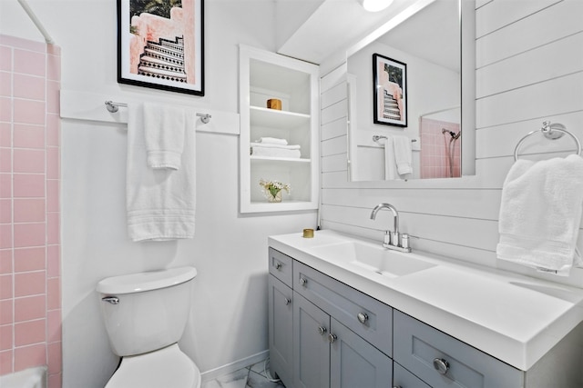 bathroom with toilet, vanity, and walk in shower