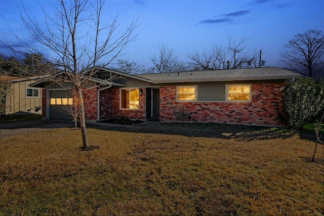 single story home with a garage and a lawn