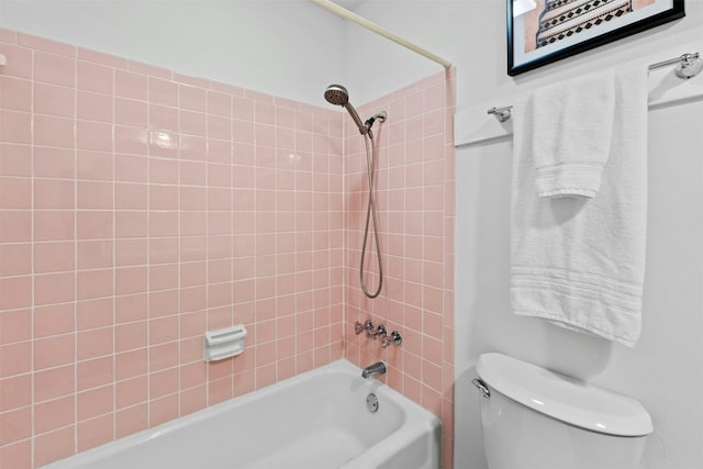 bathroom featuring tiled shower / bath combo and toilet