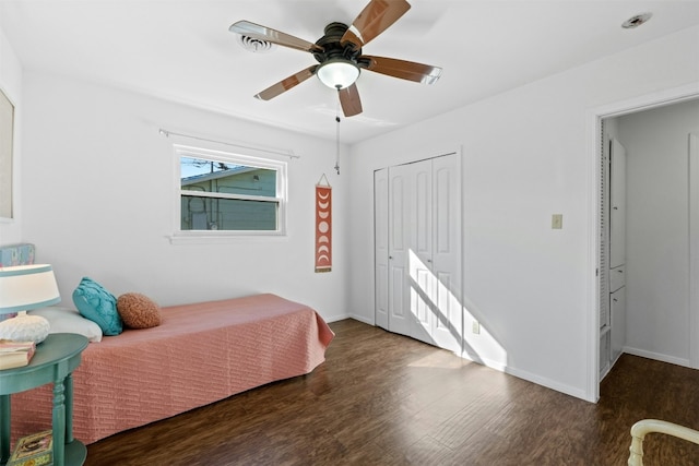 bedroom with ceiling fan, a closet, and dark hardwood / wood-style flooring