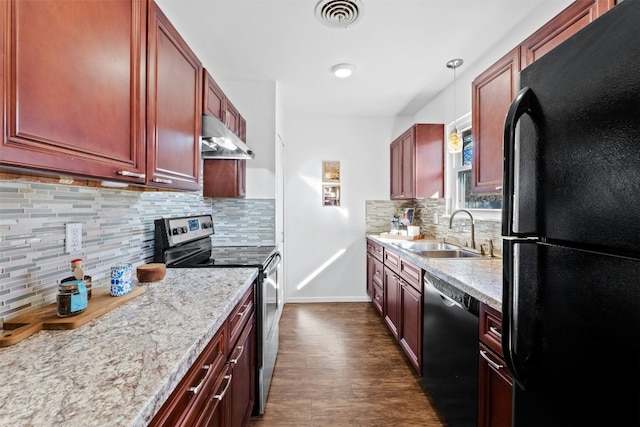 kitchen with tasteful backsplash, light stone countertops, black appliances, pendant lighting, and sink