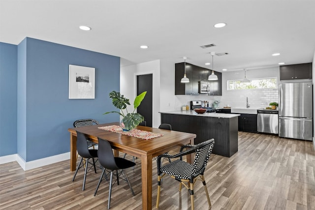 dining room featuring recessed lighting, light wood-type flooring, baseboards, and visible vents