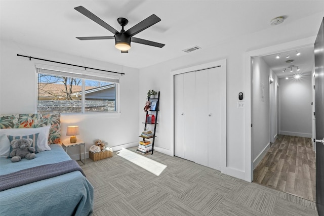 bedroom with a closet, visible vents, a ceiling fan, and baseboards