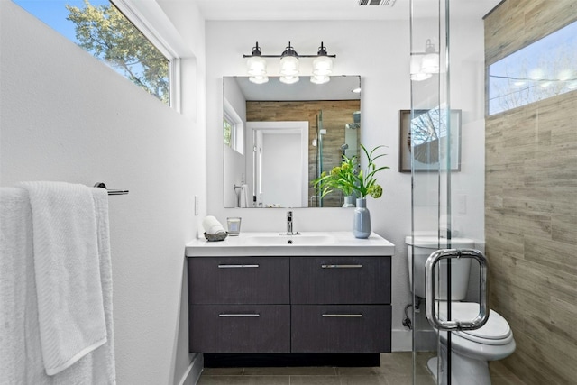 bathroom with plenty of natural light, toilet, a stall shower, and vanity