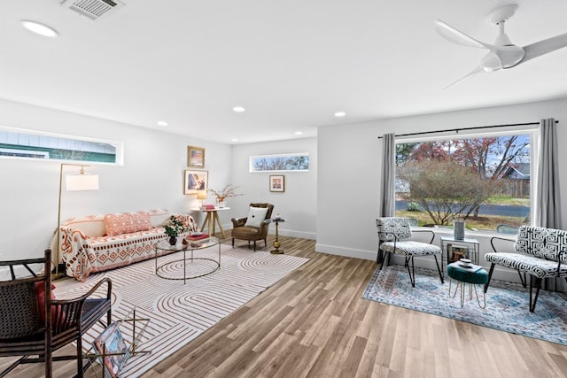 living room with a wealth of natural light, light hardwood / wood-style floors, and ceiling fan