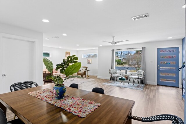 dining space with ceiling fan and light hardwood / wood-style flooring