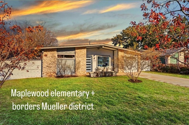 view of front of house featuring a garage and a lawn