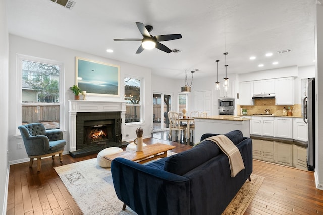 6136 Oliver Loving Trl, Austin, TX 78749 - living room featuring a ceiling fan, light wood-type flooring, a fireplace, and recessed lighting