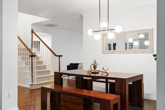 dining area with crown molding and dark wood-type flooring