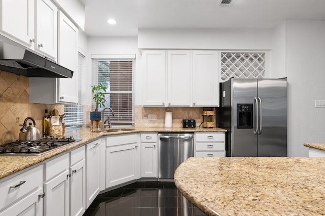 6136 Oliver Loving Trl, Austin, TX 78749 - kitchen with appliances with stainless steel finishes, white cabinetry, tasteful backsplash, under cabinet range hood, and recessed lighting