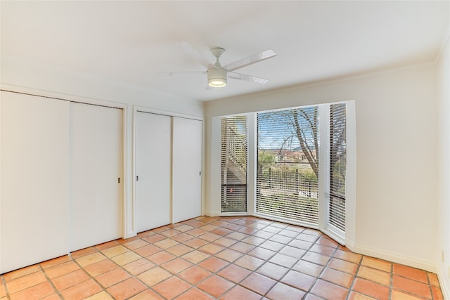 unfurnished bedroom with two closets, access to exterior, and light tile patterned floors