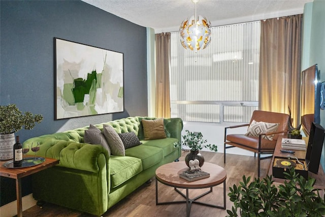 living room with an inviting chandelier, plenty of natural light, dark hardwood / wood-style floors, and a textured ceiling