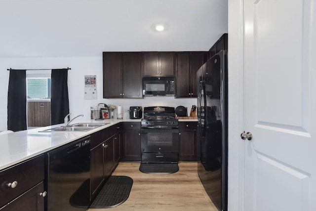 kitchen with dark brown cabinets, sink, light hardwood / wood-style flooring, and black appliances