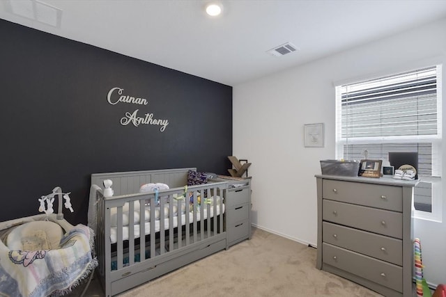 carpeted bedroom with a nursery area