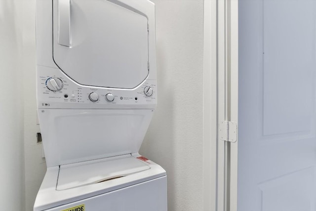 clothes washing area featuring stacked washer and clothes dryer