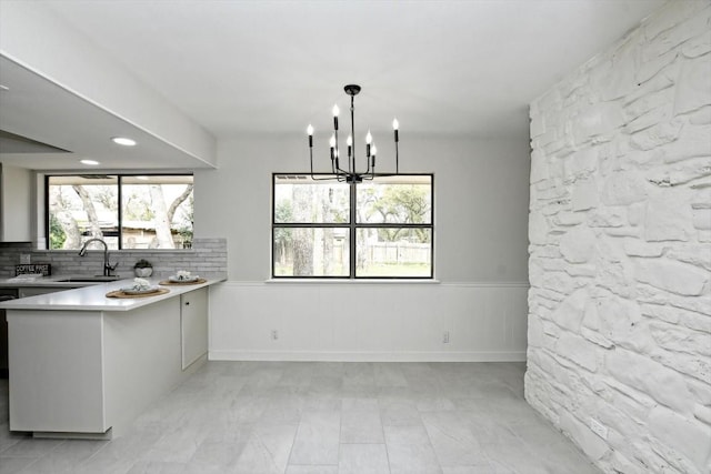 kitchen with a healthy amount of sunlight, sink, a chandelier, and decorative light fixtures