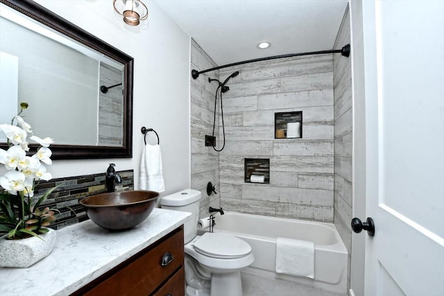 full bathroom featuring vanity, toilet, and tiled shower / bath combo