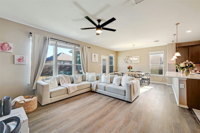 living room with ceiling fan and light wood-type flooring