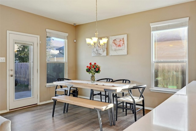 dining area with dark wood-type flooring and a chandelier